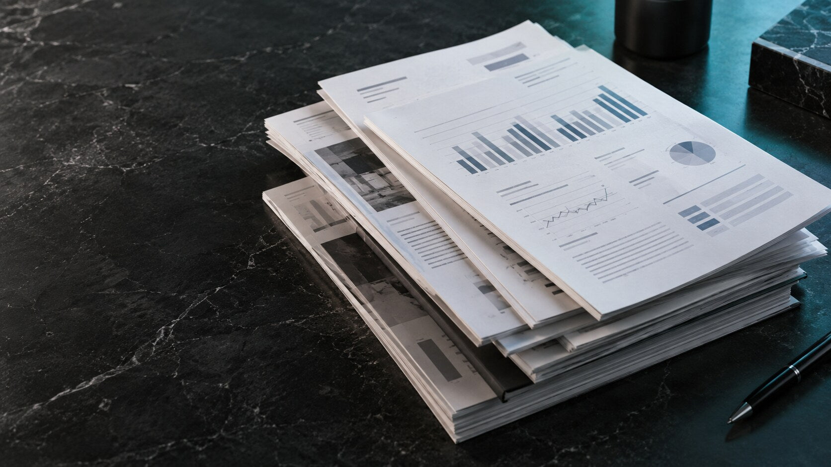 Precisely arranged printed reports on a marble table