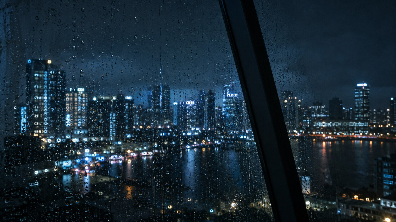 Night city lights seen through rain-covered glass